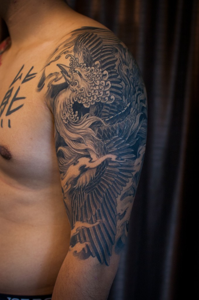 Grey Ink Phoenix Tattoo On Man Left Half Sleeve