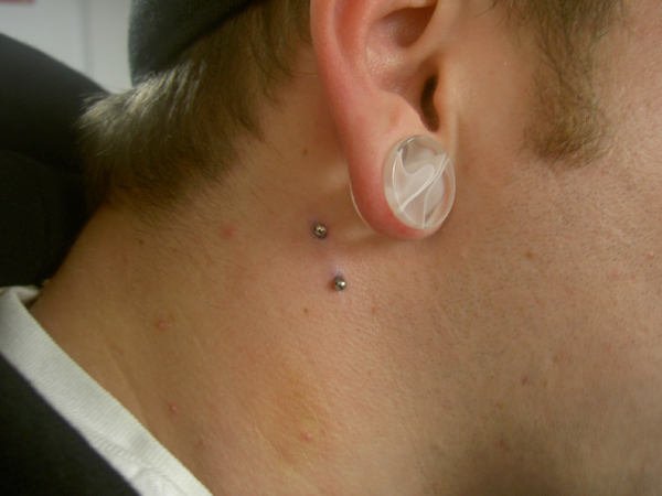 Right Ear Lobe And Side Neck Piercing With Silver Barbell