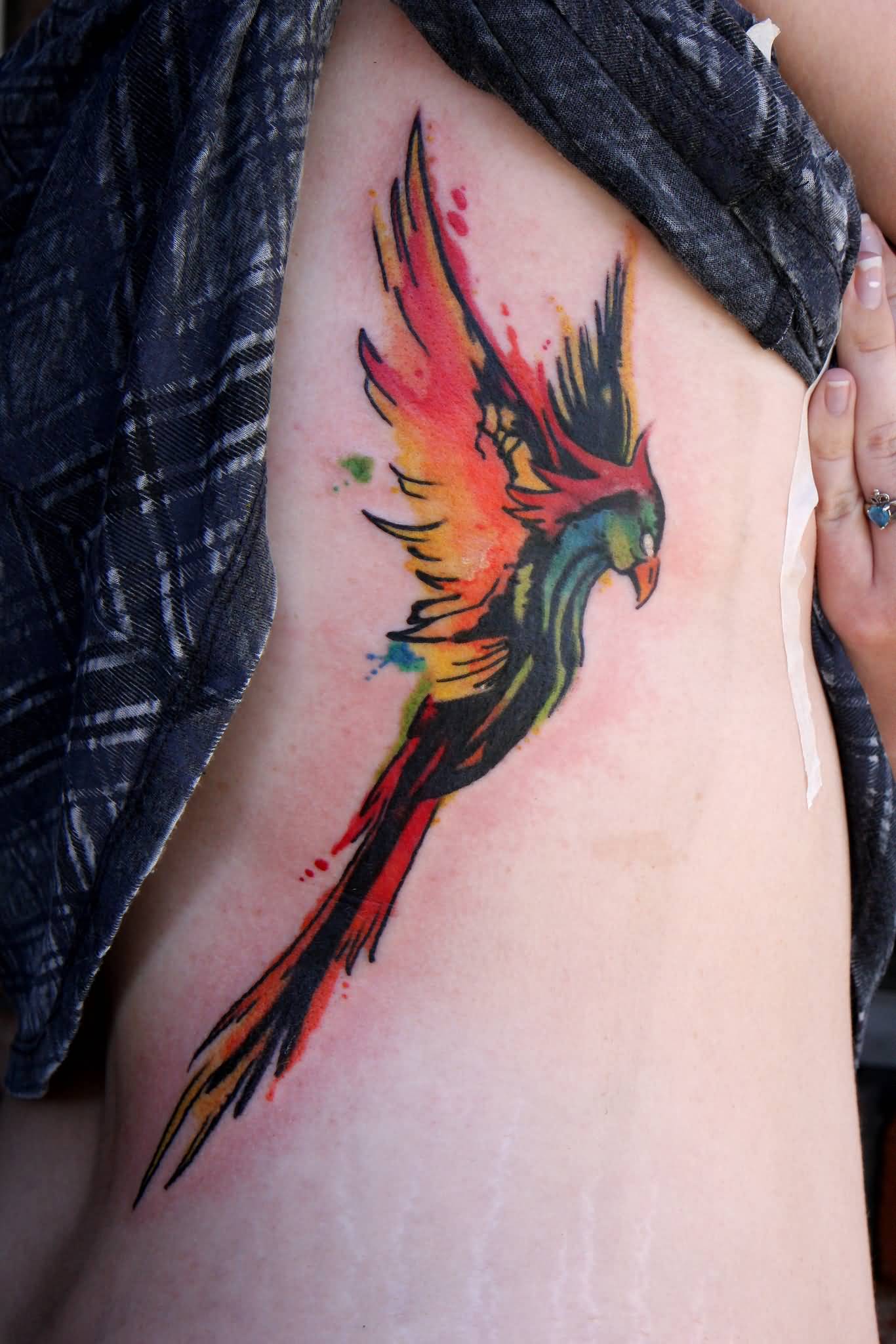 Watercolor Rising Phoenix From The Ashes Tattoo On Girl Right Side Rib