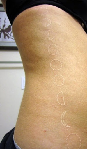 White Ink Outline Phases Of The Moon Tattoo On Right Side Rib