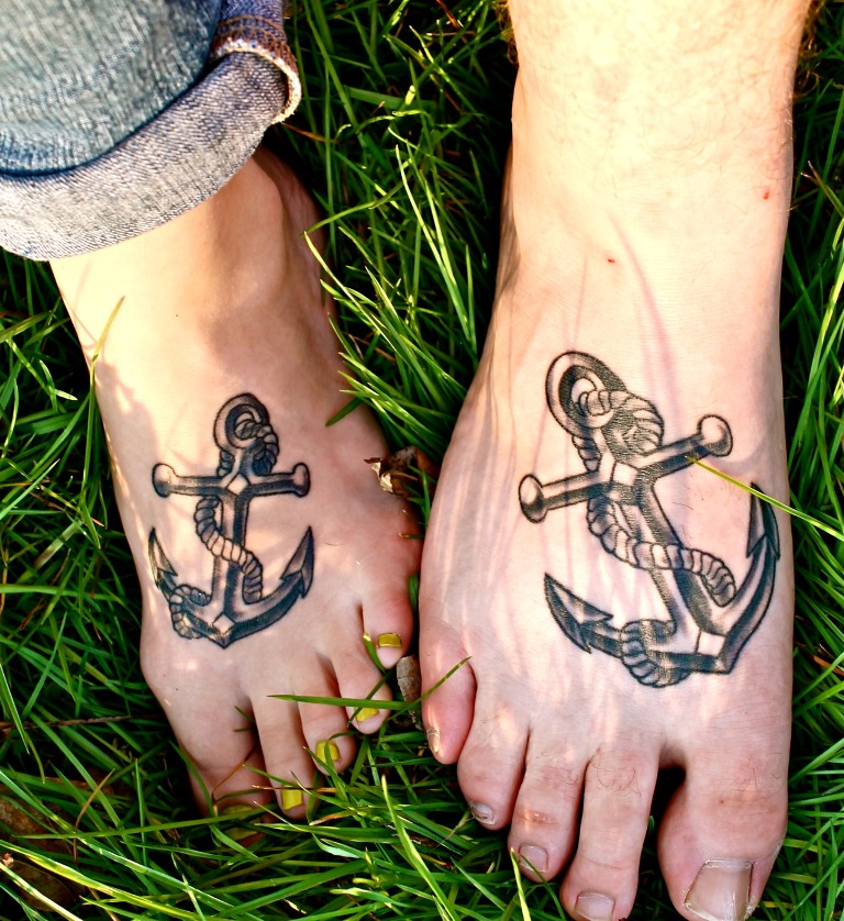 Black Ink Anchor Tattoo On Couple Foot