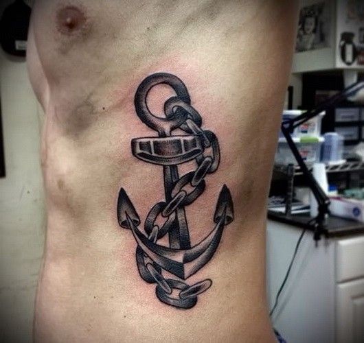 Black Ink Anchor Tattoo On Man Left Side Rib