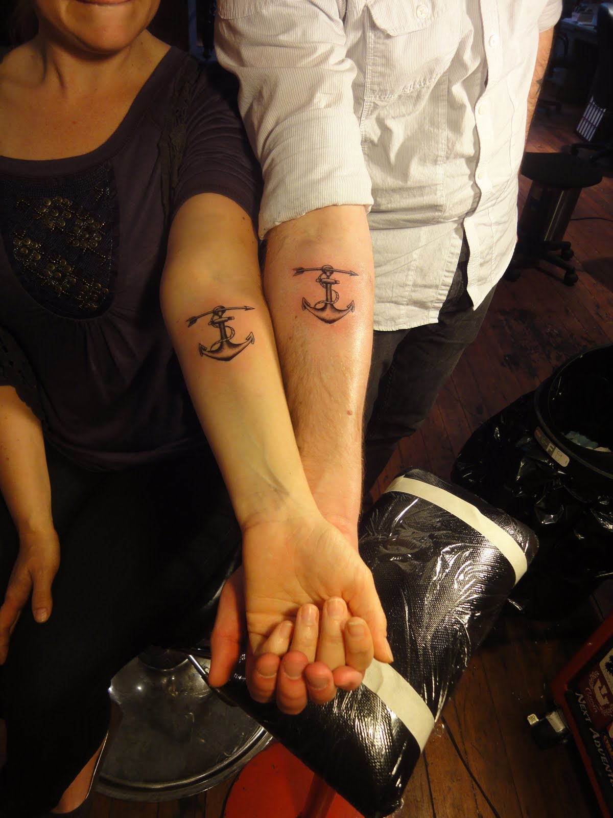 Black Ink Anchor With Arrow Tattoo On Couple Forearm