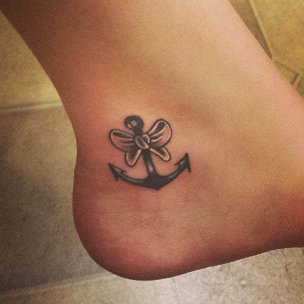 Black Ink Anchor With Bow Tattoo On Ankle