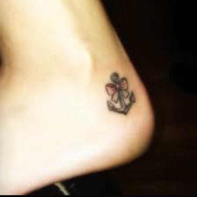 Black Ink Anchor With Bow Tattoo On Heel