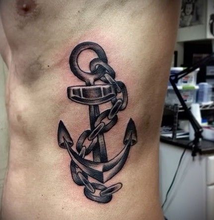 Black Ink Anchor With Chain Tattoo On Man Left Side Rib