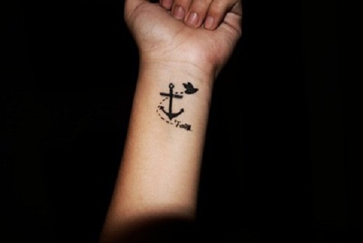 Black Ink Anchor With Flying Bird Tattoo On Left Wrist
