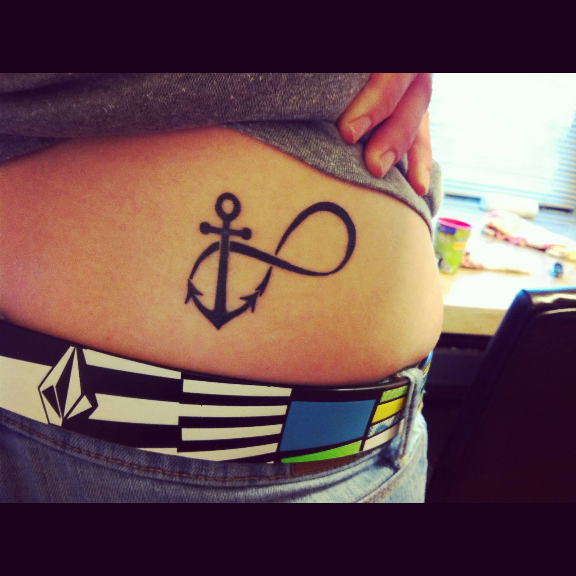 Black Ink Infinity With Anchor Tattoo On Lower Back
