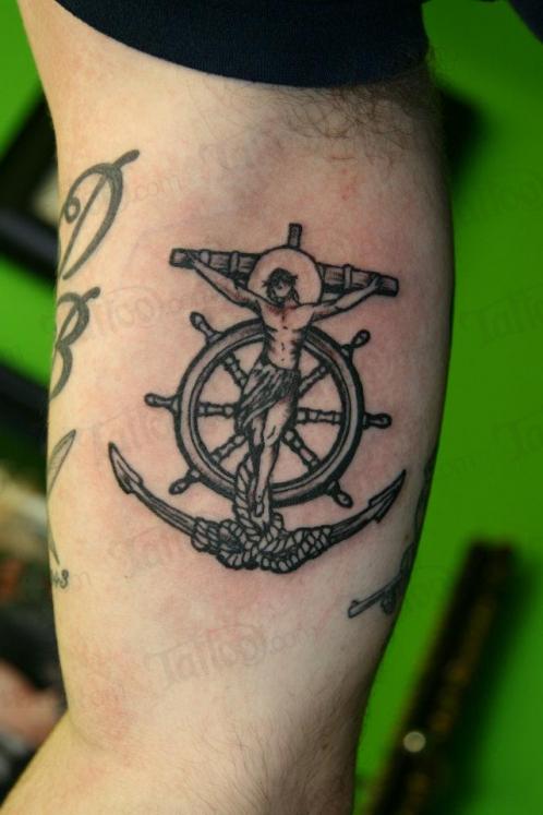 Black Ink Jesus On Anchor Cross With Ship Wheel Tattoo On Bicep