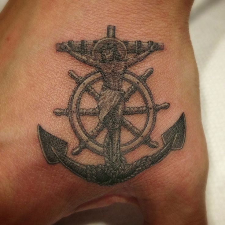 Black Ink Jesus On Anchor Cross With Ship Wheel Tattoo On Hand