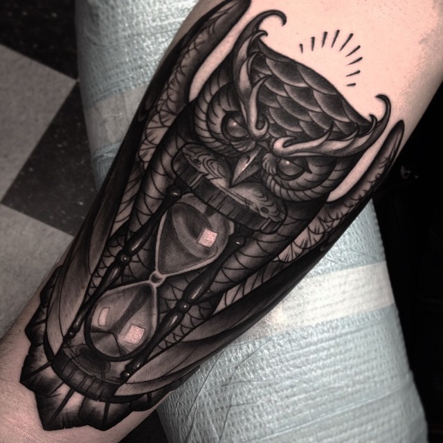 Black Ink Owl Hourglass Tattoo On Left Forearm