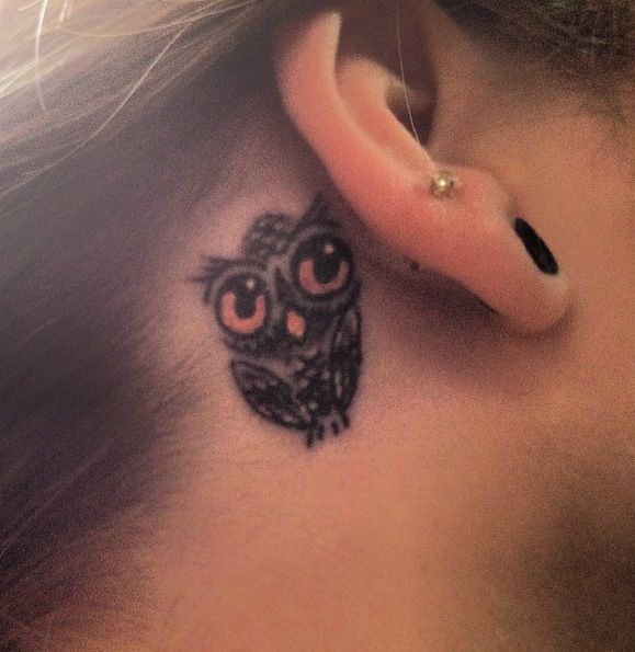 Black Ink Owl Tattoo On Girl Right Behind The Ear