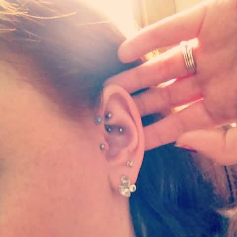 Girl showing Her Rook And Tragus Piercing