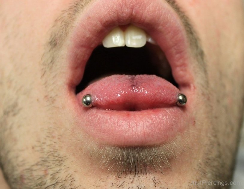 Man Showing His Venom Piercing With Silver Barbell