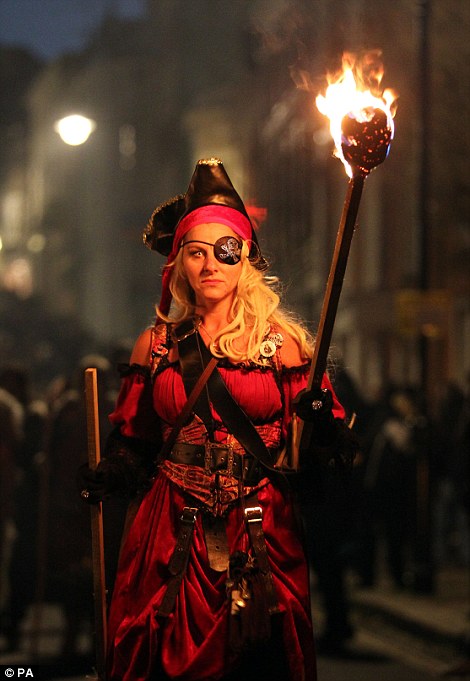 Woman Dressed In A Pirate Outfit And Brandishing A Burning Torch On Guy Fawkes Parade