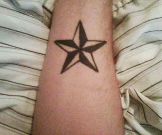 Black And White Nautical Star Tattoo On Forearm