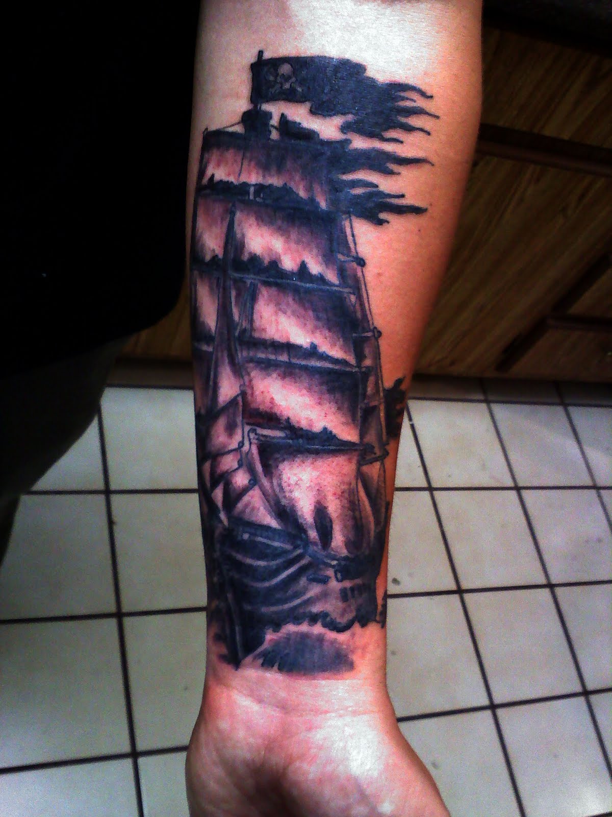 Black Ink Ghost Pirate Ship Tattoo On Left Forearm