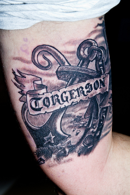 Black Ink Pirate Anchor With Banner Tattoo Design For Bicep