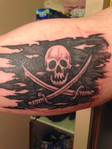 Black Ink Pirate Skull Flag Tattoo Design For Bicep