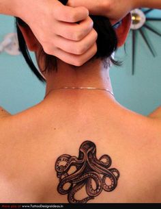 Black Ink Small Octopus Tattoo On Girl Upper Back