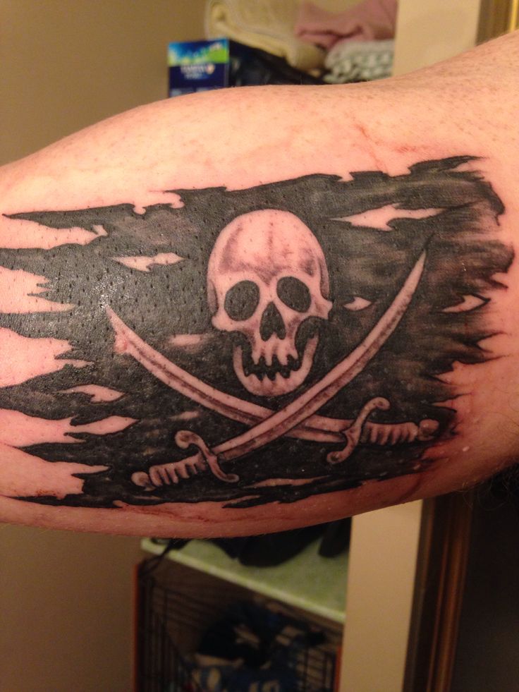 Black Ink Torn Pirate Flag Tattoo Design For Bicep