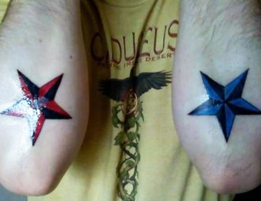 Blue And Red Nautical Star Tattoos On Elbow