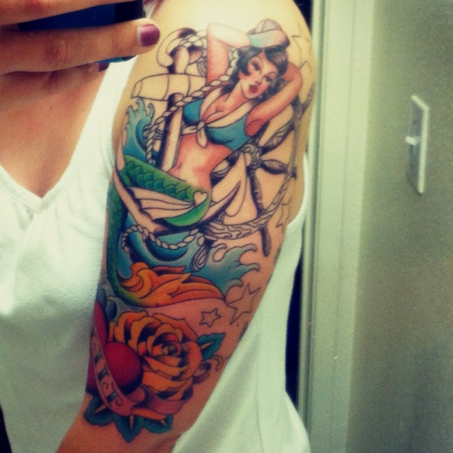 Colorful Pin Up Mermaid With Ship Wheel And Roses Tattoo On Left Half Sleeve