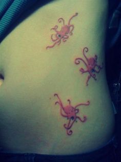 Colorful Three Small Octopus Tattoo On Girl Left Side Rib