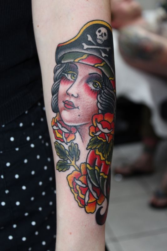 Colorful Traditional Pirate Girl Head With Flowers Tattoo On Left Arm