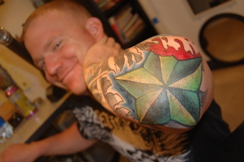 Green Nautical Star Tattoo On Man Left Elbow