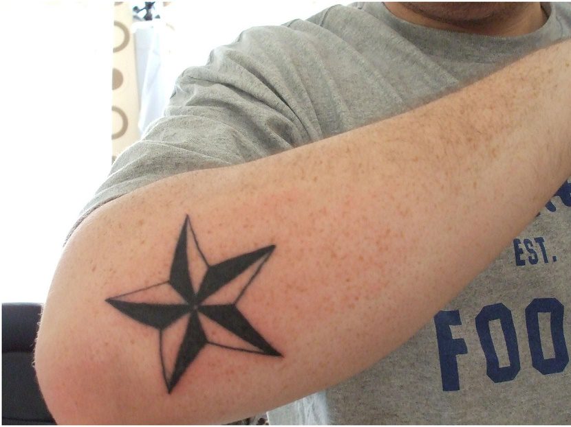 Man Showing His Star Tattoo On Right Arm