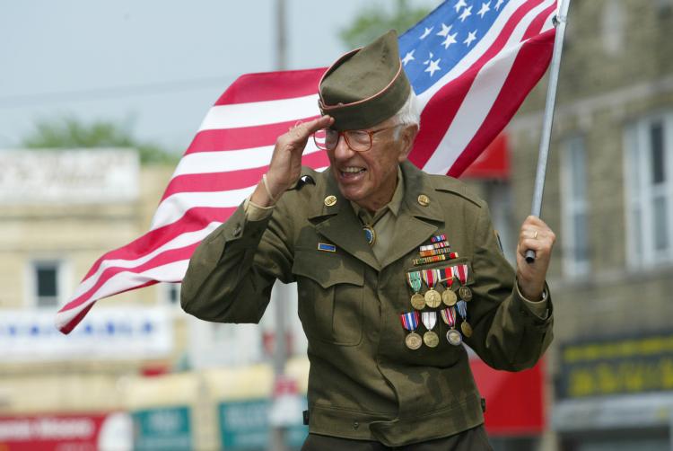 Old American Veteran Saluting During Veterans Day Parade