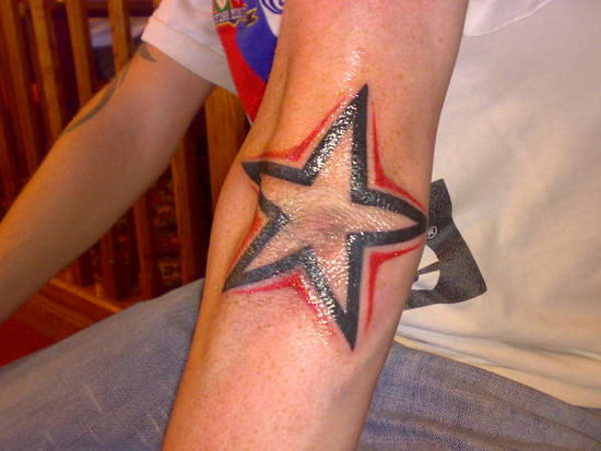 Red And Black Star Tattoo On Elbow