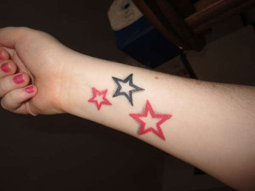 Red And Black Star Tattoos On Forearm