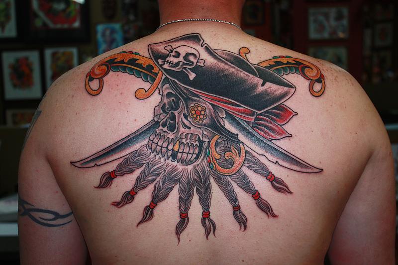 Traditional Pirate Skull With Dagger Tattoo On Man Upper Back
