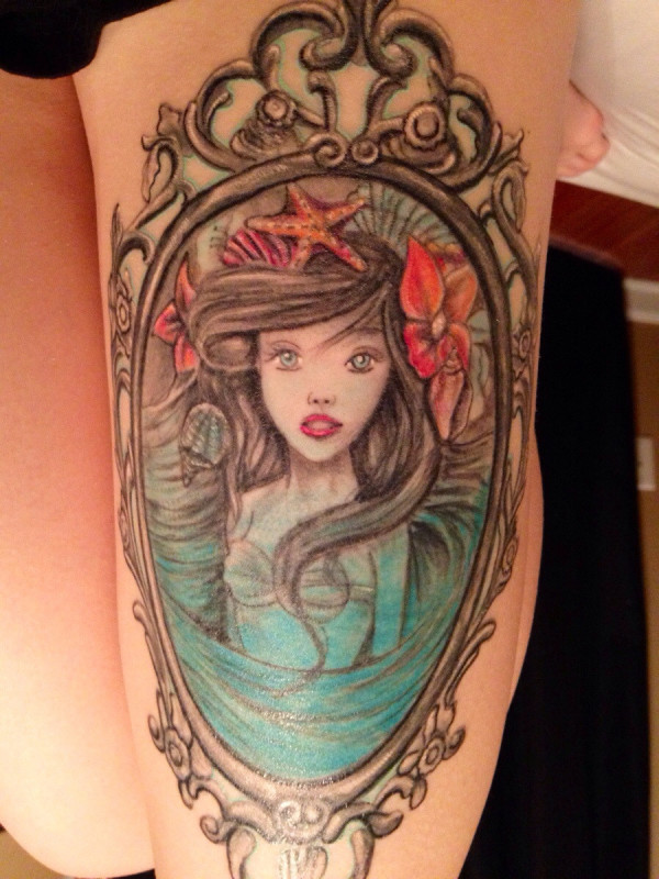 Wonderful Colorful Mermaid In Frame Tattoo On Girl Left Thigh