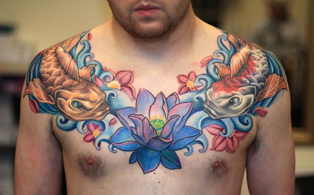 Attractive Colorful Two Koi Fish With Lotus Flower Tattoo On Man Chest