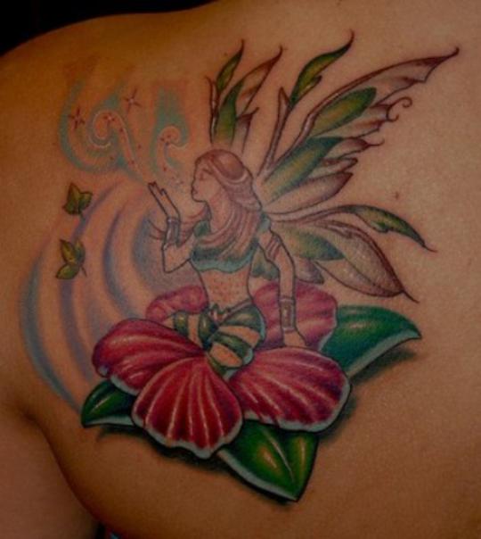 Attractive Fairy With Flower Tattoo On Left Back Shoulder