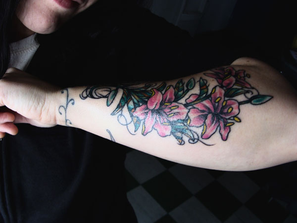 Attractive Lily Flowers Tattoo On Left Arm