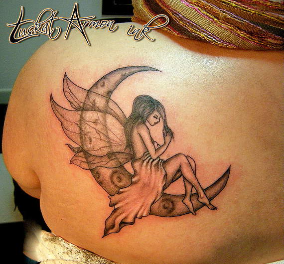 Black And Grey Fairy On Half Moon Tattoo On Girl Left Back Shoulder