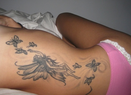 Black And Grey Fairy With Flying Butterflies Tattoo On Right Side Rib