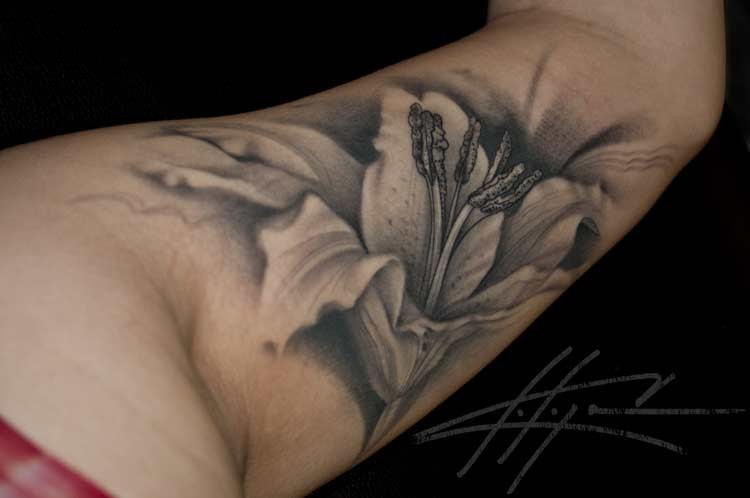 Black And Grey Lily Flower Tattoo On Left Arm