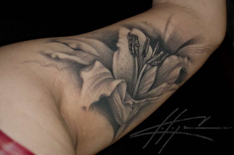 Black And Grey Lily Tattoo On Inner Bicep