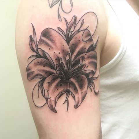 Black And Grey Lily Tattoo On Man Right Shoulder