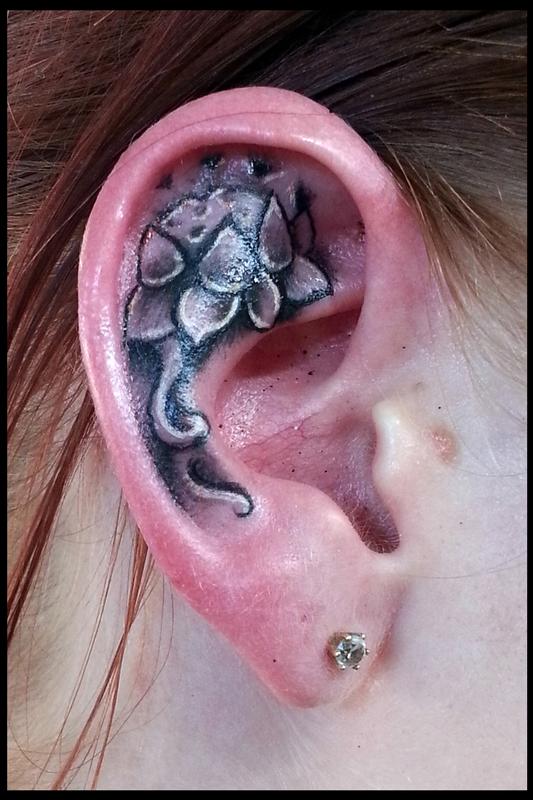 Black And Grey Lotus Tattoo On Girl Right Ear