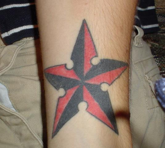 Black And Red Nautical Star Tattoo On Arm