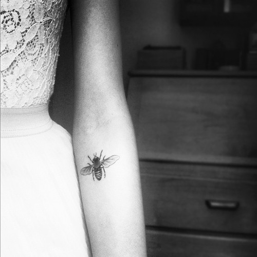 Black And White Bumblebee Tattoo On Girl Left Forearm