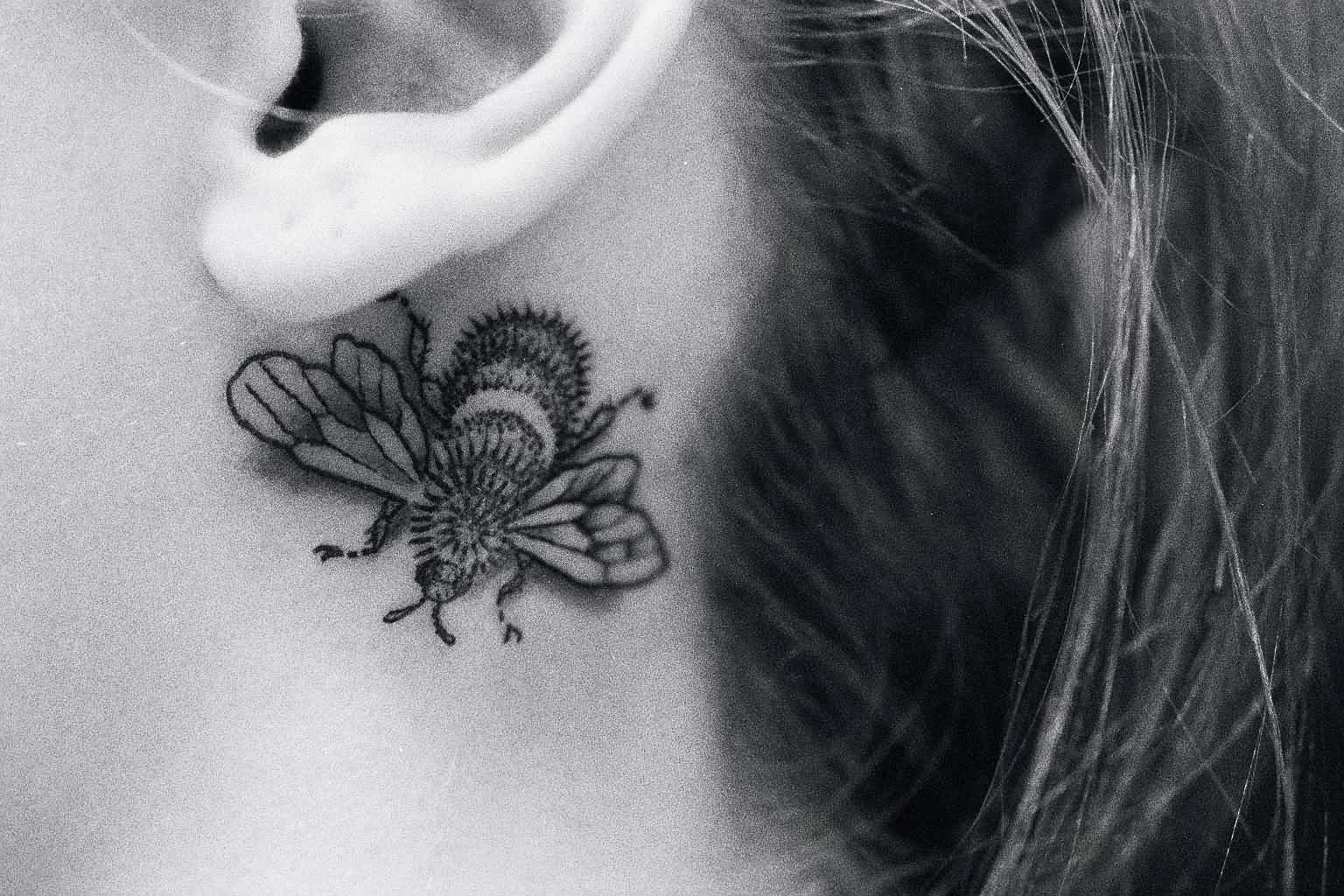 Black And White Bumblebee Tattoo On Left Behind The Ear