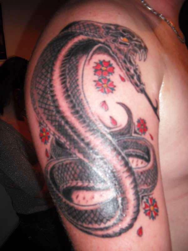 Black Ink Cobra Snake With Flowers Tattoo On Right Upper Arm