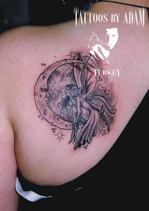 Black Ink Fairy On Half Moon Tattoo On Left Back Shoulder